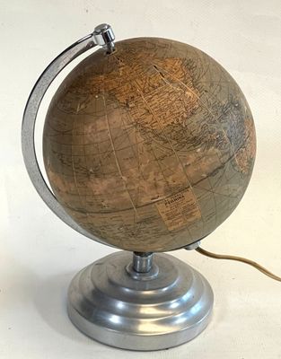 a wooden globe with a metal base on a table