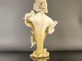 an antique figurine of a woman with a flower in her hair