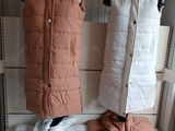 two coats hanging on a clothes rack in a room