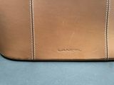 an image of a tan purse sitting on top of a table