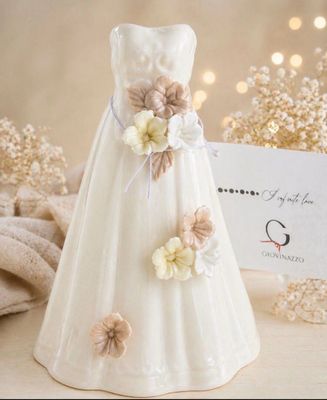 a white dress with flowers on it next to a place card