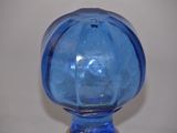 a blue glass vase sitting on a white table
