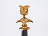 gold and black candle holder with a flower on top of it