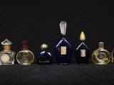 several bottles of perfume are lined up in a row on a black surface
