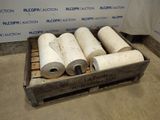 four rolls of paper sitting in a crate on the floor