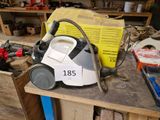 un aspirateur posé sur un établi