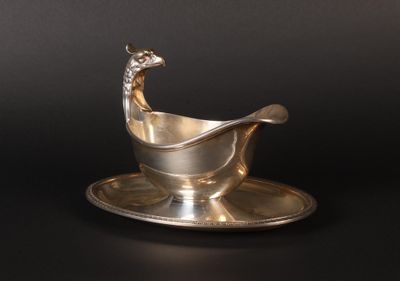a silver plate with a spoon and saucer on it