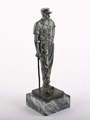 statue d'un homme coiffé d'un chapeau et muni d'une canne, debout sur un socle en marbre