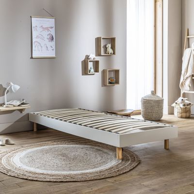 un lit blanc dans une chambre où il y a un tapis au sol