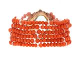 a close up of a bracelet with orange beads on a white background