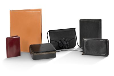 quatre modèles différents de portefeuilles en cuir et un sac à main posés sur un fond blanc