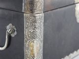 a metal box with a handle on a white surface