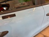 a man taking a picture of a car door handle