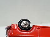 a close up of a red toy car on a white surface