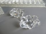 deux bougeoirs en verre transparent posés sur une table