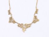 a close up of a gold necklace on a white background