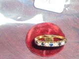 une bague en or sertie de pierres bleues et blanches