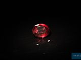 a close up of a red diamond on a black surface