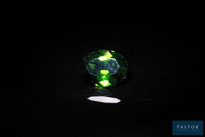 un gros plan d'un anneau vert et noir sur une surface noire
