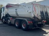 a garbage truck that is parked in front of a building