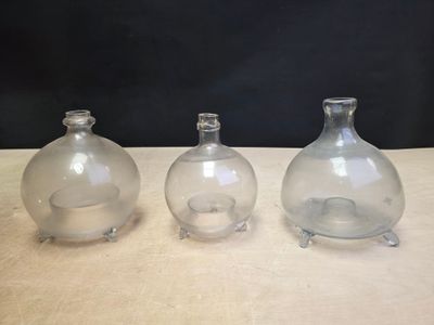 three clear glass vases sitting on top of a wooden table