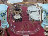 Plusieurs vases et assiettes sont posés sur une table recouverte d'une nappe rouge.