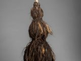 a close up of a stuffed animal with long hair on a gray background