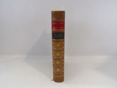 un grand livre marron sur lequel est posée une bougie