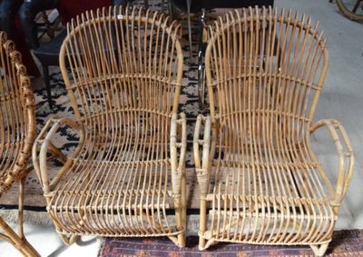 deux chaises en osier et une table dans une pièce où se trouve un tapis