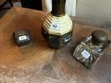une petite table sur laquelle se trouvent un vase et deux flacons de parfum