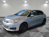 a silver citrole parked on a checkered floor in a garage