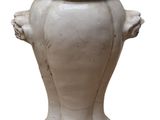 un vase blanc orné d'un visage sur fond blanc