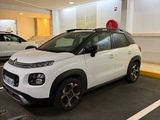 a small white car parked in a parking lot