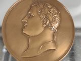 une image représentant une médaille d'or sur laquelle figure le visage d'un homme