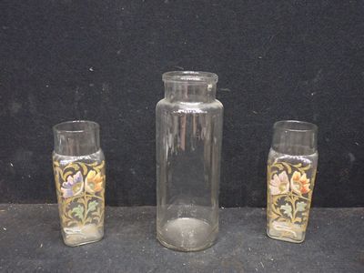 trois vases en verre posés l'un à côté de l'autre sur une table