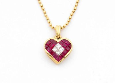 un pendentif en forme de cœur, orné d'un diamant et d'un rubis, monté sur une chaîne en or