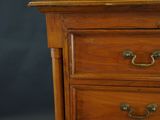 a close up of a wooden dresser with a clock on top of it