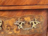 a wooden chest of drawers with brass handles on it