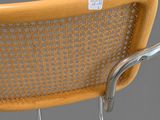 the back of a chair with a metal frame and wicker seat