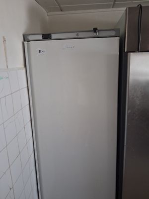 a refrigerator in the corner of a kitchen with tile on the floor