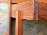 a close up of a wooden table with a wallpapered wall behind it