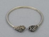 a close up of a silver bracelet with two skulls on it