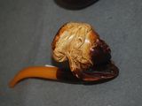 a pipe with a man ' s face on it on a table