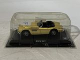 a yellow toy car in a clear case on a table