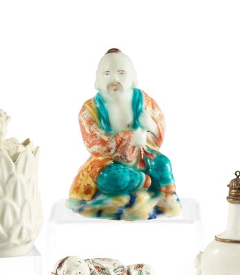 quatre figurines asiatiques différentes exposées sur un socle blanc