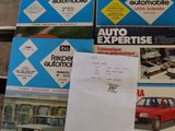 several boxes of auto expertise on a wooden table with papers on it