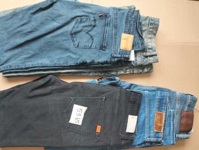 deux paires de jeans pour homme posées sur une boîte en carton