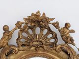 a mirror with a gold frame with angels and flowers on it