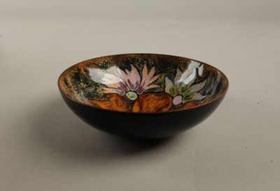 un bol noir orné d'un motif floral