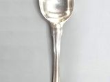 silver spoon on a white surface with a small spoon sticking out of it